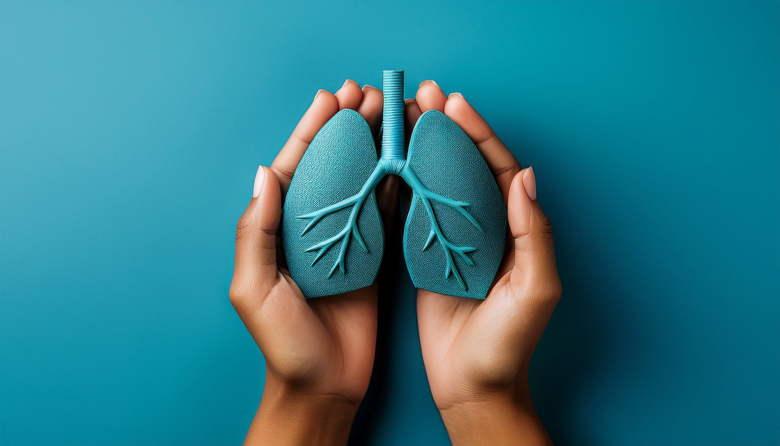 Hands holding a blue set of lungs in the palms holding the lungs